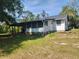 Rear exterior view of home featuring a covered porch and expansive yard at 1880 N Sparkman Ave, Orange City, FL 32763