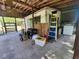 Rustic covered garage with vintage light fixture, supplies, and stacked laundry machines at 1880 N Sparkman Ave, Orange City, FL 32763