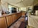 Functional kitchen featuring wooden cabinets, practical countertops, and natural light from surrounding windows at 1880 N Sparkman Ave, Orange City, FL 32763