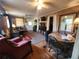 Cozy living room featuring wood floors, wood paneling, ceiling fans, and a wood burning stove at 1880 N Sparkman Ave, Orange City, FL 32763