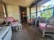 Enclosed front porch furnished with wicker seating, perfect for relaxing at 1880 N Sparkman Ave, Orange City, FL 32763
