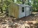 Angle of a storage shed with a single door in a leafy, wooded area at 1880 N Sparkman Ave, Orange City, FL 32763