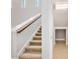 Carpeted staircase with white banister and wooden handrail leads to the upper level of the home at 1923 Mendocino Ln, Port Orange, FL 32128