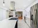 Modern kitchen featuring stainless steel appliances, custom range hood, island cooktop, and white cabinetry at 200 Alpine St, Altamonte Springs, FL 32701