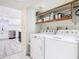 Bright laundry room with washer, dryer, and shelving adjacent to the kitchen at 200 Alpine St, Altamonte Springs, FL 32701