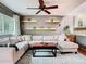 Comfortable living room featuring a ceiling fan and a cozy sectional sofa with decorative pillows at 200 Alpine St, Altamonte Springs, FL 32701