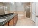 Bathroom featuring dual sinks, a large bathtub, and glass shower at 201 Dyson Dr, Deland, FL 32724