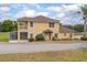 Tan home featuring a balcony, front yard landscaping, and a screened-in porch at 201 Dyson Dr, Deland, FL 32724
