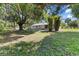 Lush backyard featuring mature trees, open green space, and a view of the house at 2106 Umbrella Tree Dr, Edgewater, FL 32141