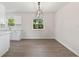 Bright dining area featuring gray flooring and a modern light fixture, adjacent to a clean white kitchen at 2106 Umbrella Tree Dr, Edgewater, FL 32141