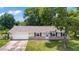 Charming one-story home featuring a brick facade, attached garage, and well-manicured lawn on a sunny day at 2106 Umbrella Tree Dr, Edgewater, FL 32141