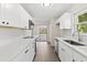 Stylish kitchen featuring white cabinetry, stainless steel appliances, quartz countertops, and modern backsplash tiles at 2106 Umbrella Tree Dr, Edgewater, FL 32141