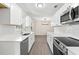 Updated kitchen featuring white cabinets, quartz countertops, stainless steel appliances, and a view to the adjacent dining room at 2106 Umbrella Tree Dr, Edgewater, FL 32141