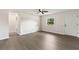 Clean, open living room featuring new gray flooring, a ceiling fan, a large window, and a front door at 2106 Umbrella Tree Dr, Edgewater, FL 32141