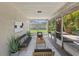 Cozy screened-in porch with comfortable seating and tranquil backyard views at 2106 Umbrella Tree Dr, Edgewater, FL 32141