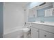 Clean bathroom with white fixtures and light blue walls, featuring a tub and updated vanity and sink at 2226 Sherwood Dr, South Daytona, FL 32119