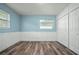 The empty bedroom features light blue walls, white trim, a window, and closet, offering a versatile living space at 2226 Sherwood Dr, South Daytona, FL 32119
