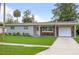 Charming single-story home boasts a well-manicured lawn, brick accents, and an attached carport at 2226 Sherwood Dr, South Daytona, FL 32119