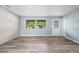 The living room features a brick accent wall, ample natural light, and stylish, easy-to-clean wood-look floors at 2226 Sherwood Dr, South Daytona, FL 32119