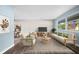Bright living room features a whitewashed brick wall, light wood floors, and contemporary furniture at 2226 Sherwood Dr, South Daytona, FL 32119