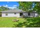 Spacious backyard features a patio seating area, a fire pit, and lush green grass at 2747 Date Palm Dr, Edgewater, FL 32141