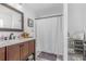 Bathroom featuring a wood vanity, shower with curtain, decorative mirror, and tile flooring at 2884 Sweet Springs St, Deltona, FL 32738