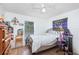 Bedroom featuring a metal bed frame, ceiling fan, wood-look flooring and a window at 2884 Sweet Springs St, Deltona, FL 32738