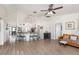 Open-concept living space with barstool seating at the counter looking into the kitchen, wood-look floors, and ceiling fan at 2884 Sweet Springs St, Deltona, FL 32738