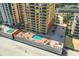 Aerial view of the condo building with private pool, hot tub, outdoor tables and seating at 2901 S Atlantic Ave # 401, Daytona Beach Shores, FL 32118