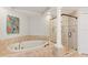 Luxurious bathroom featuring a soaking tub, separate shower, and elegant tile work at 2901 S Atlantic Ave # 401, Daytona Beach Shores, FL 32118