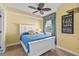 Bedroom with blue bedspread, ceiling fan, and a view out of the window at 2901 S Atlantic Ave # 401, Daytona Beach Shores, FL 32118