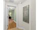 Hallway view with an open doorway leading to a bedroom with green walls and hardwood flooring at 2901 S Atlantic Ave # 401, Daytona Beach Shores, FL 32118