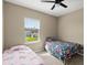 Bright bedroom with twin beds, ceiling fan, and scenic view at 2916 Meleto Blvd, New Smyrna Beach, FL 32168