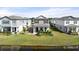 Charming two-story home features a welcoming front porch and manicured landscaping, set against a backdrop of a pond at 2916 Meleto Blvd, New Smyrna Beach, FL 32168