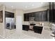 Stylish kitchen showcasing dark cabinetry, stainless steel appliances, and granite countertops at 2916 Meleto Blvd, New Smyrna Beach, FL 32168