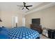Main bedroom with a ceiling fan, television, and bed with a patterned comforter at 2916 Meleto Blvd, New Smyrna Beach, FL 32168