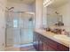 Bathroom featuring double sinks with dark wood cabinets, granite countertops, and a glass-enclosed shower at 2919 Sime St, New Smyrna Beach, FL 32168