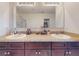 Bathroom with double sinks, dark wood vanity, granite counters, and large mirror at 2919 Sime St, New Smyrna Beach, FL 32168