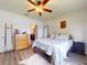 Bright bedroom with wood floors, ceiling fan, a modern metal bedframe, and ensuite bathroom at 2919 Sime St, New Smyrna Beach, FL 32168