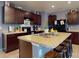 Well-lit kitchen featuring dark wood cabinets, stainless steel appliances, a central island with seating, and generous counter space at 2919 Sime St, New Smyrna Beach, FL 32168
