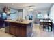 Spacious kitchen featuring wood cabinets, stainless steel appliances, an island with bar stools, and an open dining and living area at 2919 Sime St, New Smyrna Beach, FL 32168