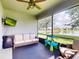 Screened lanai overlooking a pond with ceiling fan, television, and outdoor furniture at 2919 Sime St, New Smyrna Beach, FL 32168