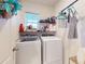 Functional laundry room featuring modern washer and dryer, ample shelving and natural light at 2919 Sime St, New Smyrna Beach, FL 32168