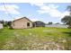 A view of the fenced backyard with some green grass and the rear exterior of the home at 2980 Lockwood Blvd, Deltona, FL 32738