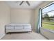 A simple bedroom that features a double bed, ceiling fan and large window to the yard at 2980 Lockwood Blvd, Deltona, FL 32738