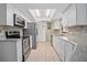 Modern kitchen featuring stainless steel appliances, white cabinets, and ample counter space with an open view at 2980 Lockwood Blvd, Deltona, FL 32738