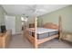 Cozy bedroom featuring a four poster bed, a ceiling fan, and a view into the en suite bath at 2980 Lockwood Blvd, Deltona, FL 32738