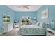 Comfortable bedroom with bright blue walls, ceiling fan, and a sunny window view at 302 Tammie Sue Ln, Deland, FL 32724