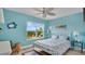 Bright bedroom with bright blue walls, ceiling fan, and views to lush greenery outside at 302 Tammie Sue Ln, Deland, FL 32724