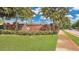 Welcoming brick entrance sign for Carriage Homes with lush landscaping and manicured lawn at 302 Tammie Sue Ln, Deland, FL 32724